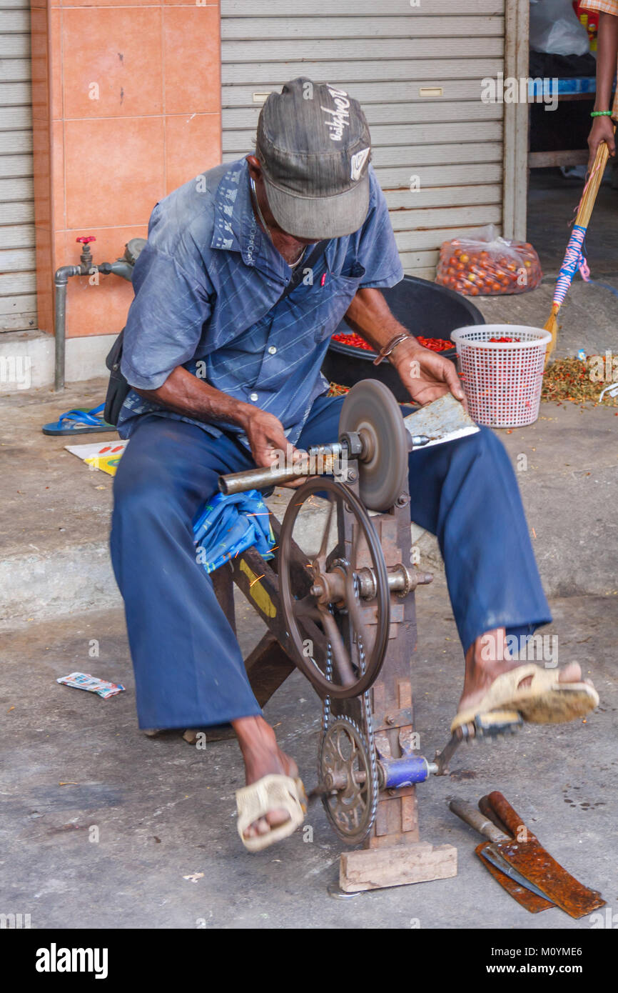Man sharpening tools on a grinding wheel, Mae Sot, Thailand Stock Photo