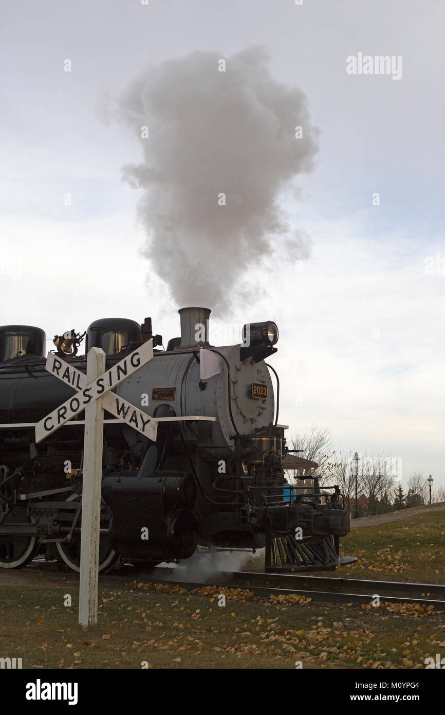 Historic steam train at railway crossing Heritage Park Historical Stock