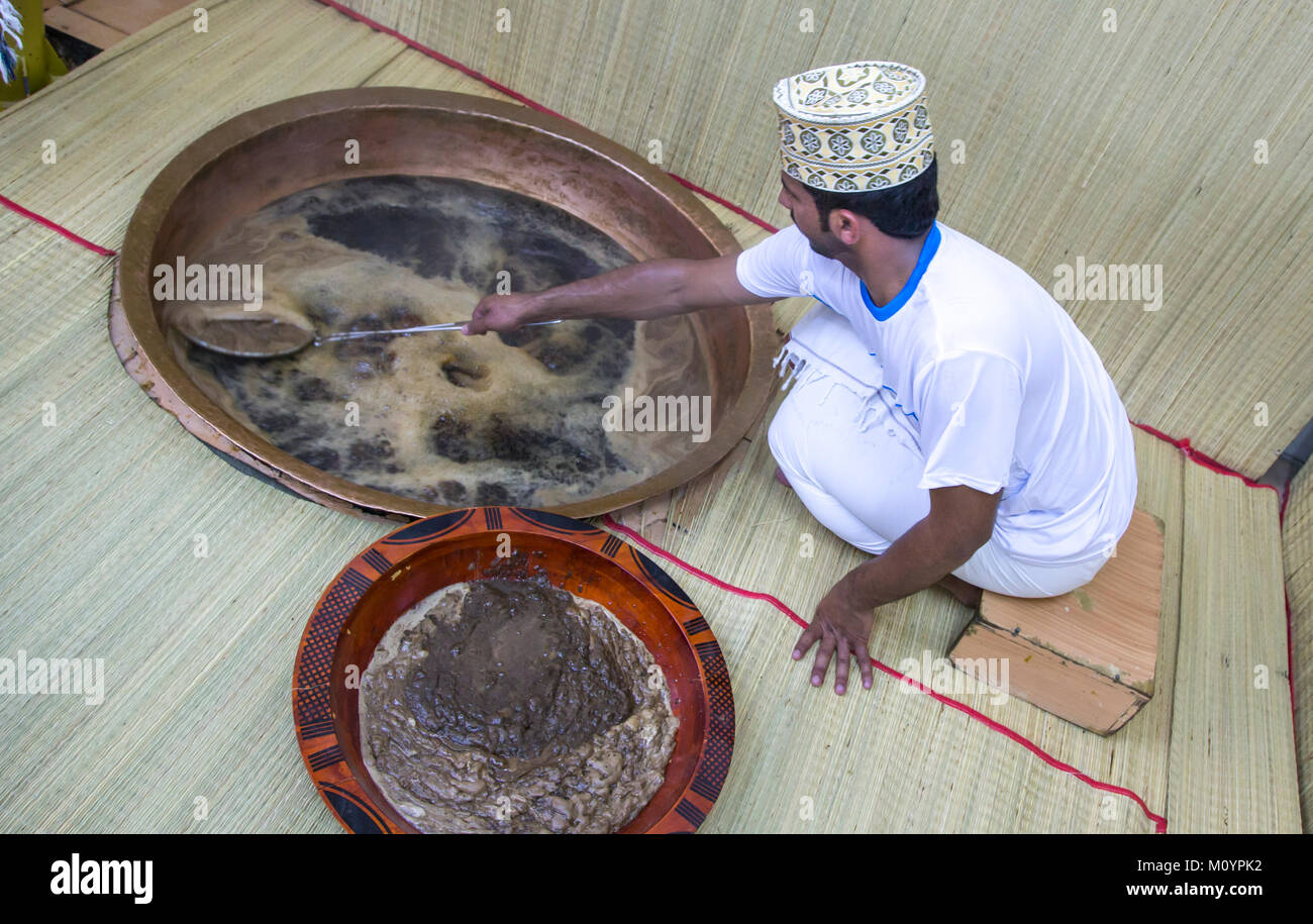 Nizwa, Oman, 26th May, 2016: worker at a halwa factory mixing a pot of halwa Stock Photo