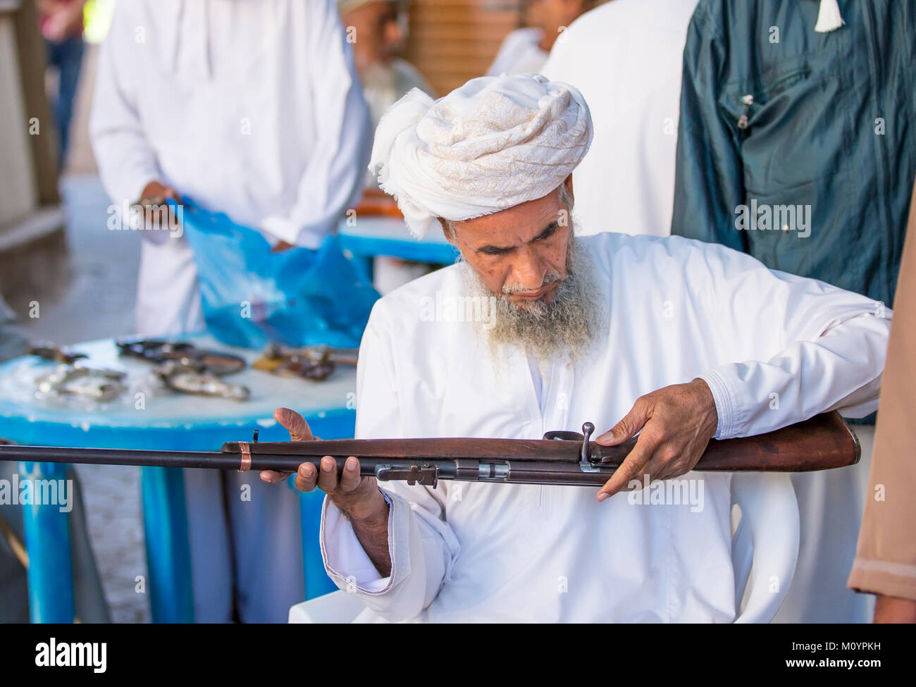 Nizwa, Oman, 24th March, 2017: omani man selling a hunting rifle at a market Stock Photo