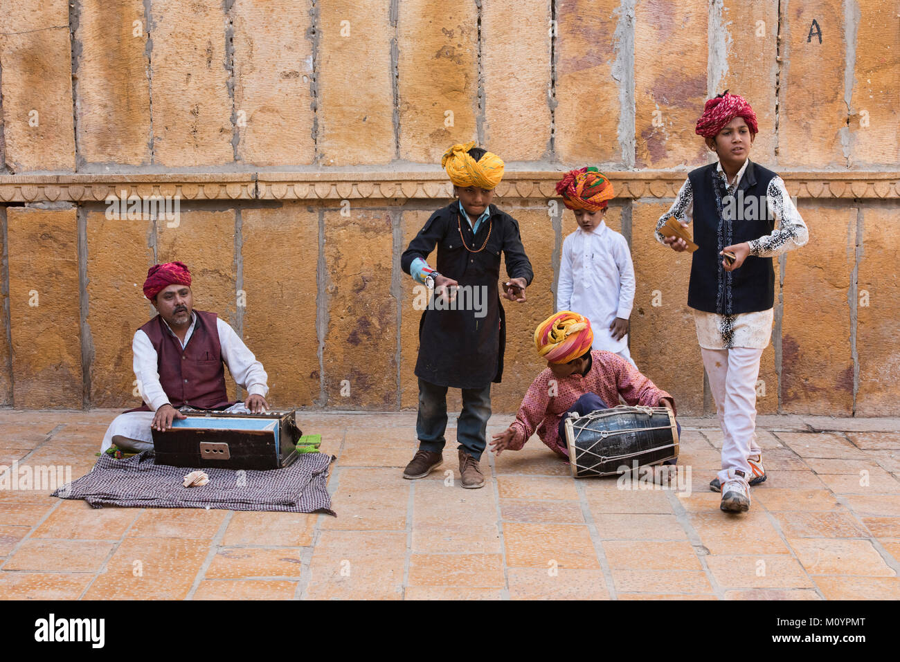 Child musicians busking outside of the Patwon Ji Ki Haveli, Jaisalmer, Rajasthan, India Stock Photo