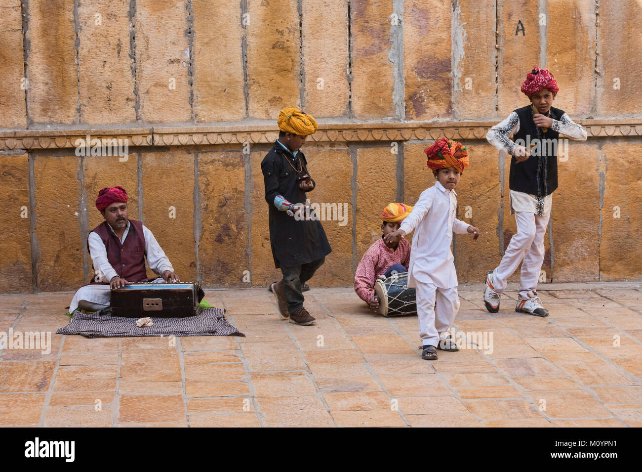 Child musicians busking outside of the Patwon Ji Ki Haveli, Jaisalmer, Rajasthan, India Stock Photo