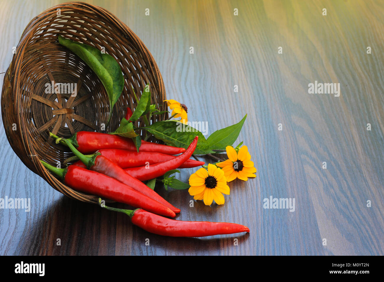 hot pepper with flowers in a basket on the table Stock Photo