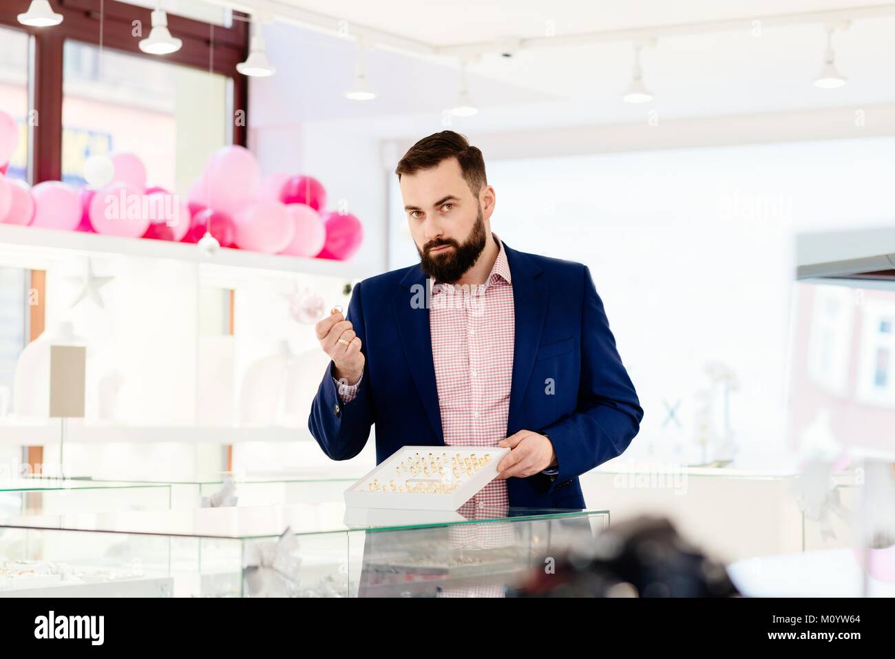 Attractive man with a beard showing a collection of wedding rings
