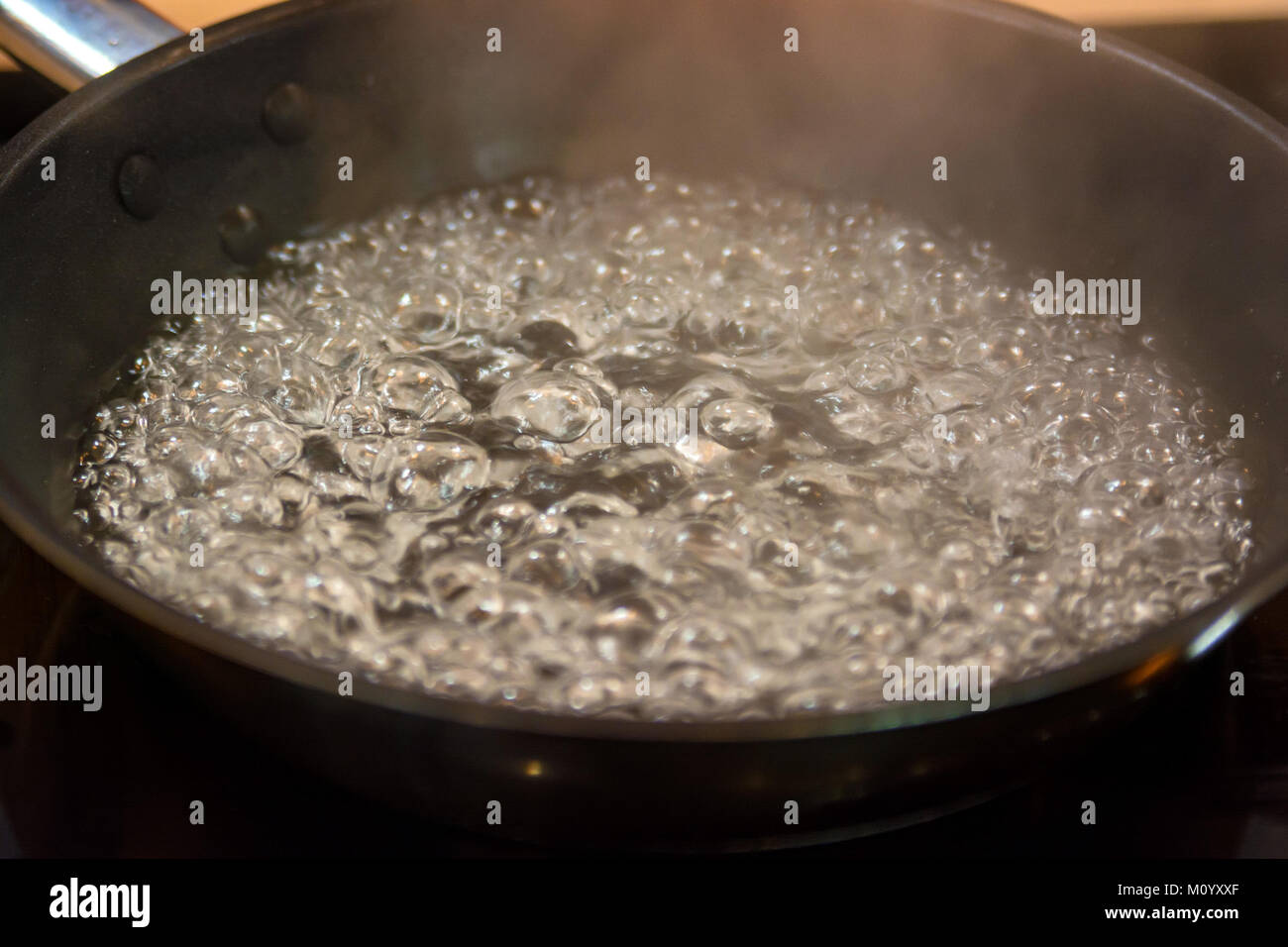 Boiling oil in frying pan on stove close Stock Photo Alamy