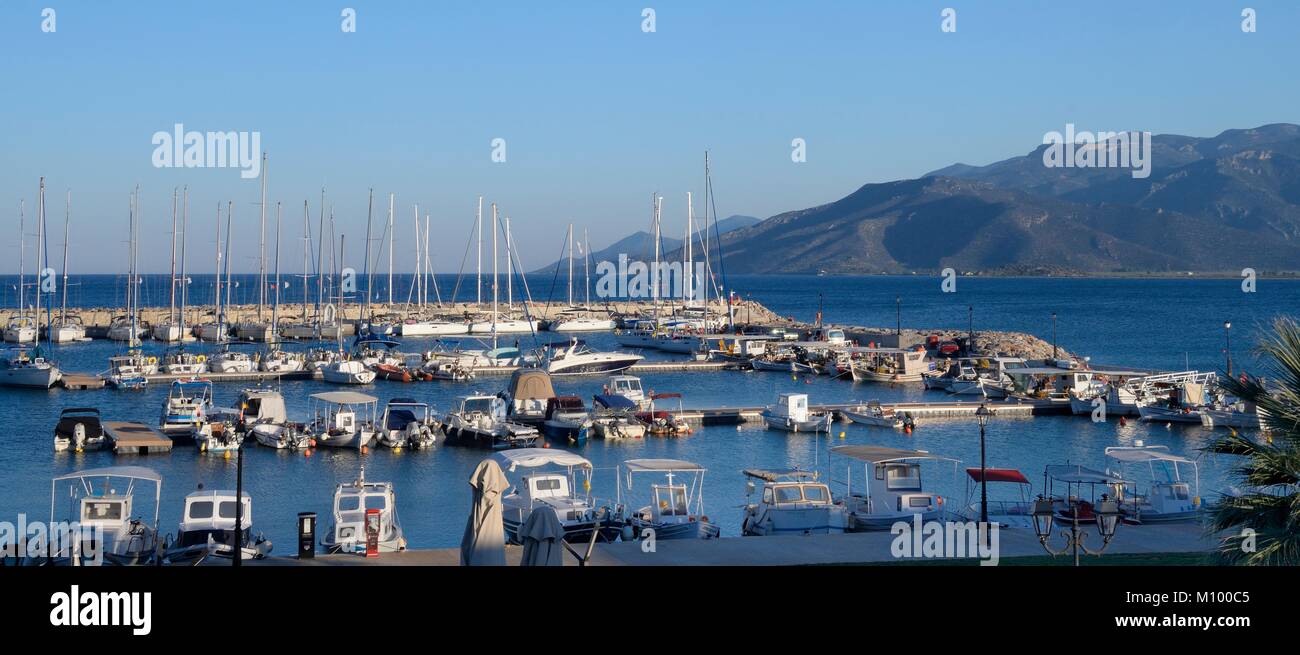 Yachts and fishing boats moored in Paralio Astros harbour at sunset with the mountains of southern Arcadia in the background, Peloponnese, Greece. Stock Photo