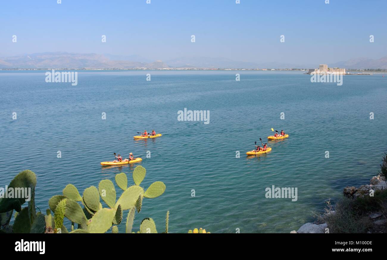 Sea kayakers paddling round the coast near Nafplio in the Argolic Gulf, Argolis, Peloponnese, Greece, August. Stock Photo