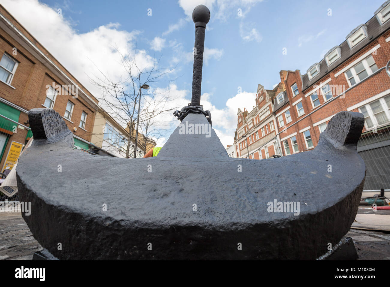 London, UK. 25th Jan, 2018. The iconic Deptford Anchor is finally returned to its original place at the south end of Deptford High Street after being removed in 2013 for high street redevelopment works. Seen here being painted on its new cobblestone base shortly after being lifted into position. The Anchor forms part of Deptford's rich maritime history. Credit: Guy Corbishley/Alamy Live News Stock Photo