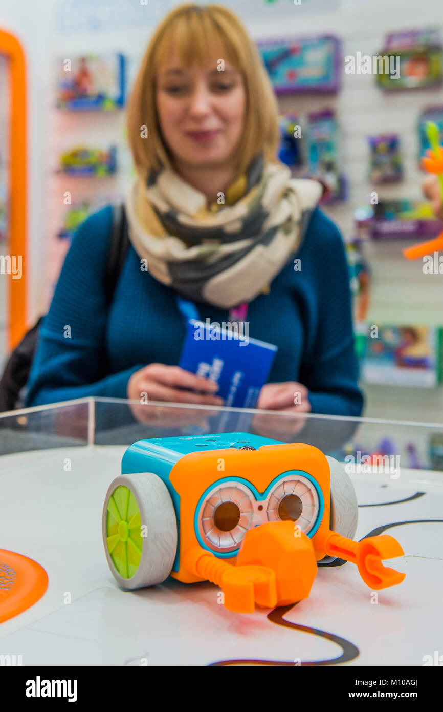 London, UK. 25th Jan, 2018. Botley the coding robot follows a programmed route on the Learning Resources Stand, watched by a potential buyer - The annual Toy Fair at Olympia, London. Credit: Guy Bell/Alamy Live News Stock Photo