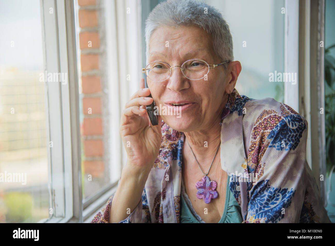 Senior woman having a friendly talk on her cell phone Stock Photo - Alamy