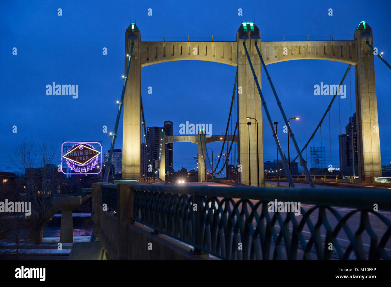 Hennepin Avenue Bridge and the iconic Grain Belt Beer sign in downtown Minneapolis, MN - The bridge is named after 17th century explorer Father Louis  Stock Photo
