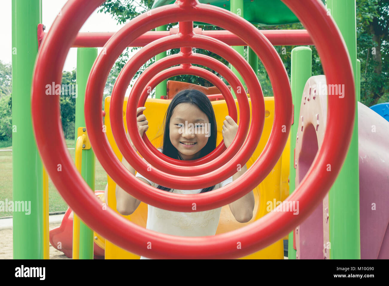 Adorable and Holiday Concept : Cute little child feeling funny and happiness on playground in the park. Stock Photo