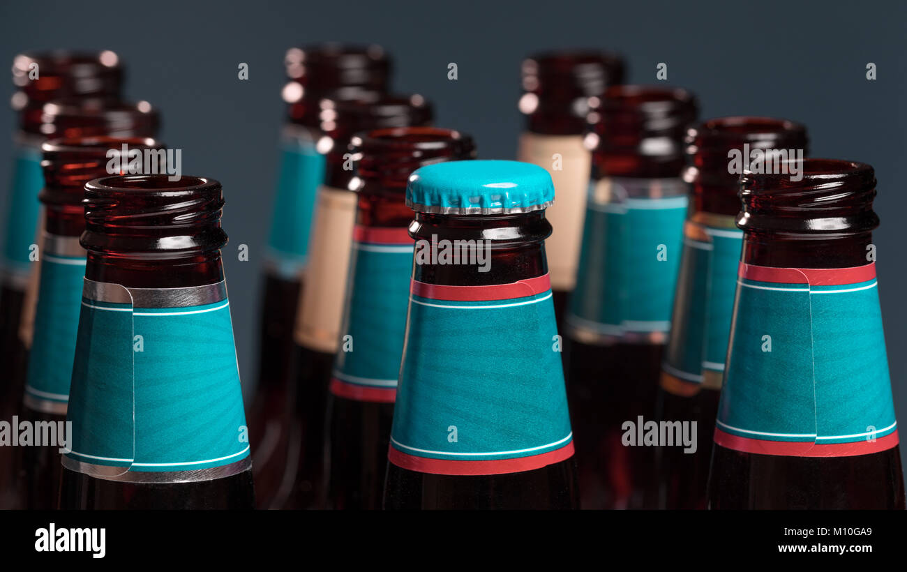 A bottle of beer in front of other empty bottles. Concept for solitude metaphor or lonely identity Stock Photo