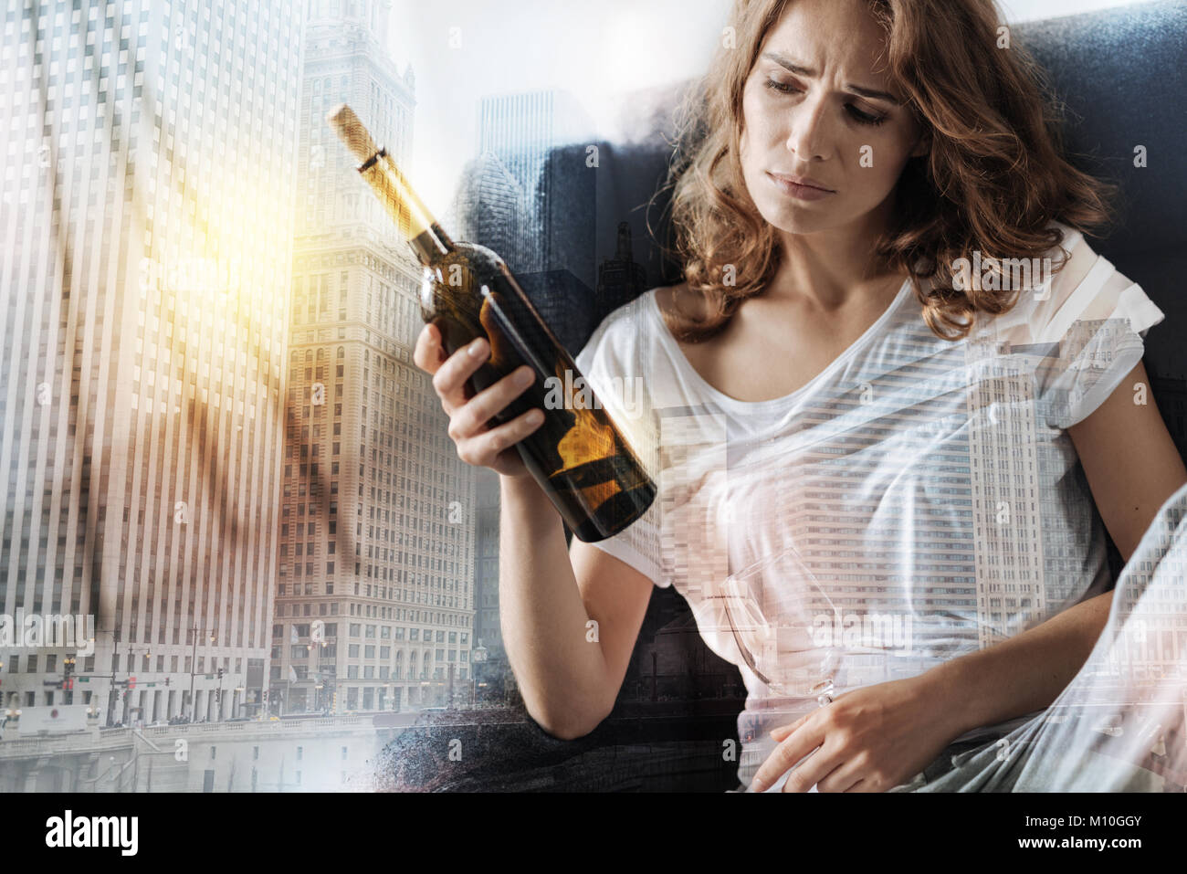 Upset woman drinking alcohol at home Stock Photo