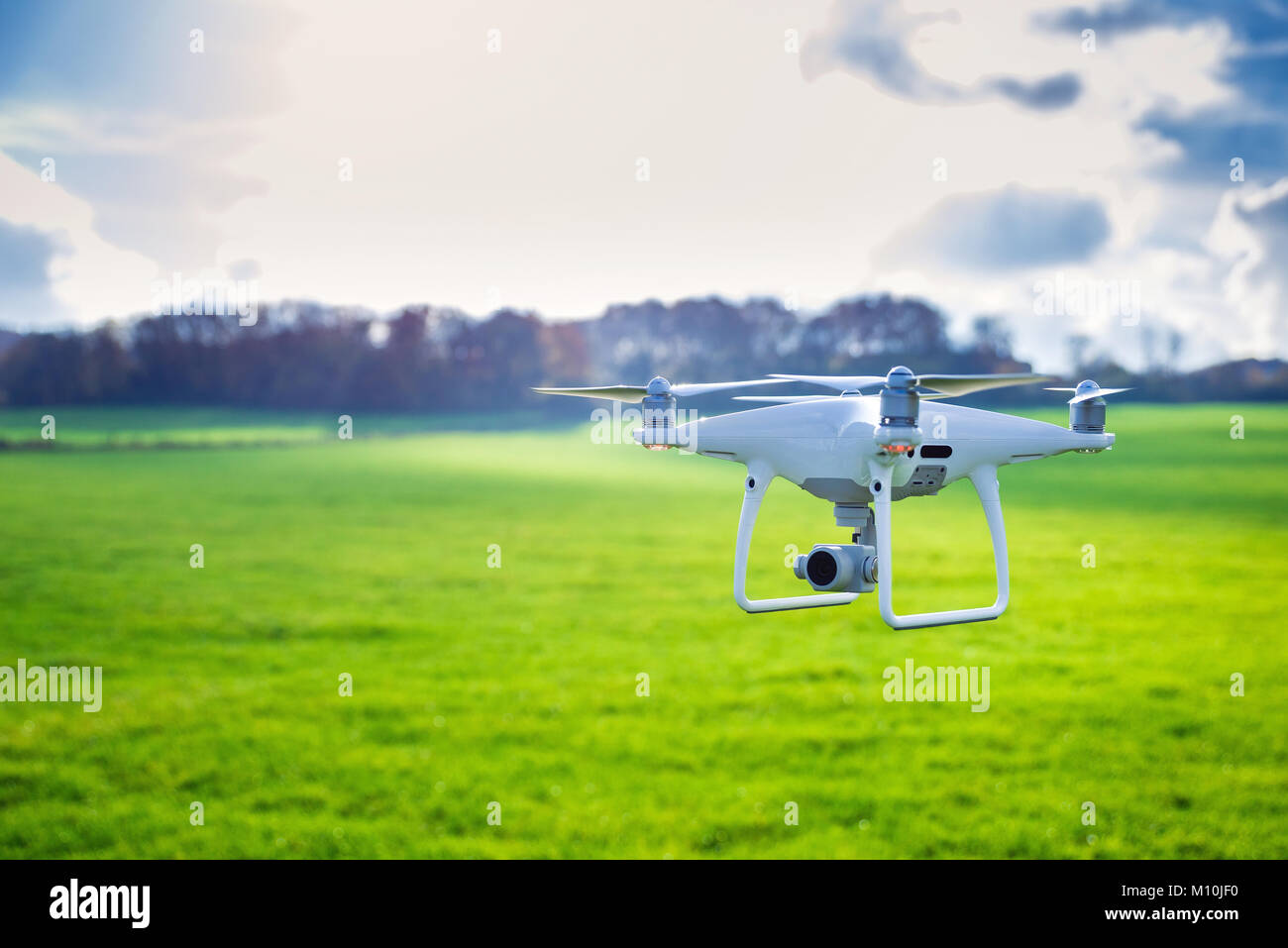 Photo of a flying white professional quadcopter drone camera in front ...