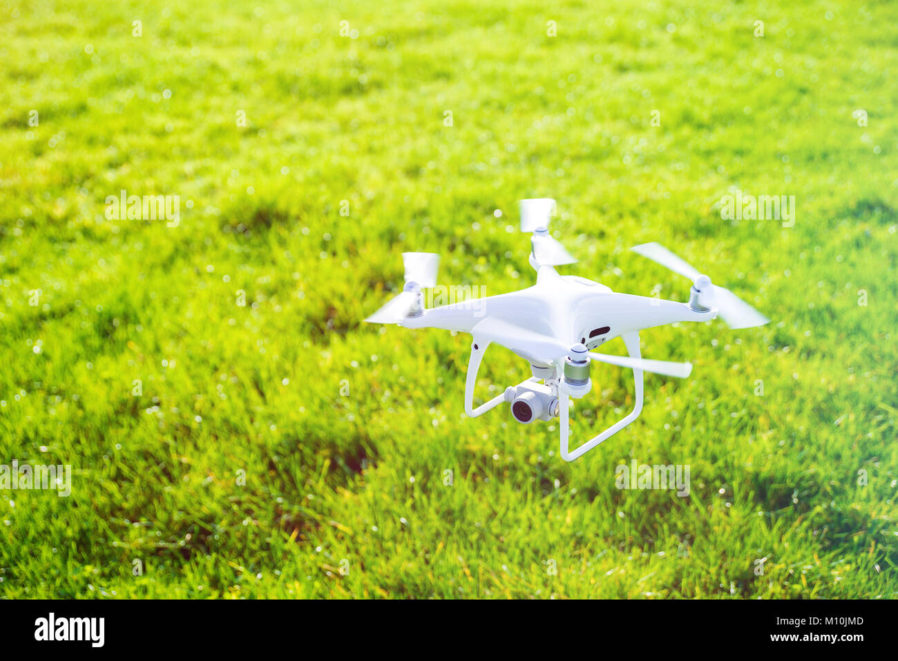Photo of a flying white professional quadcopter drone camera with green ...