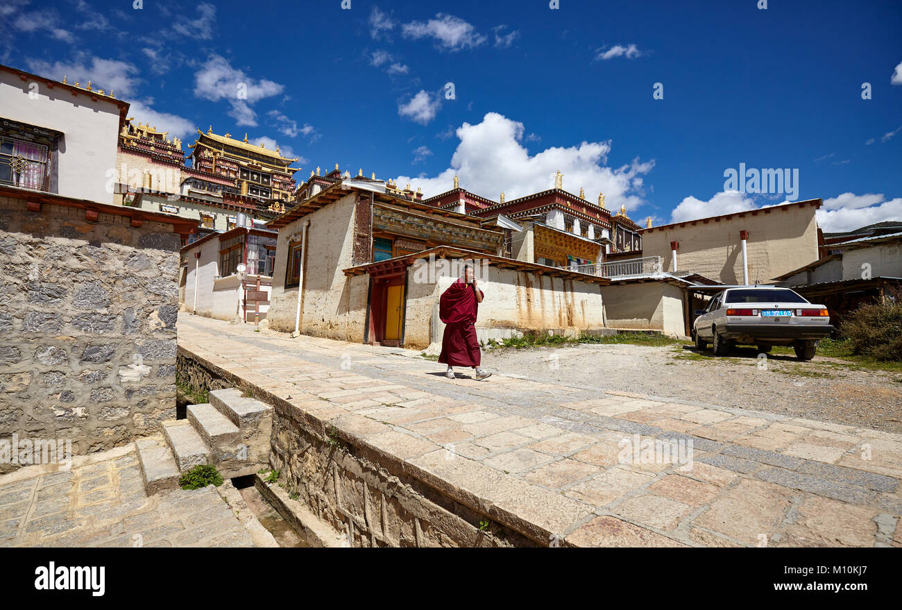 Shangri-La, China - September 25, 2017: Monk walks down the road in Songzanlin Monastery, built in 1679. Stock Photo