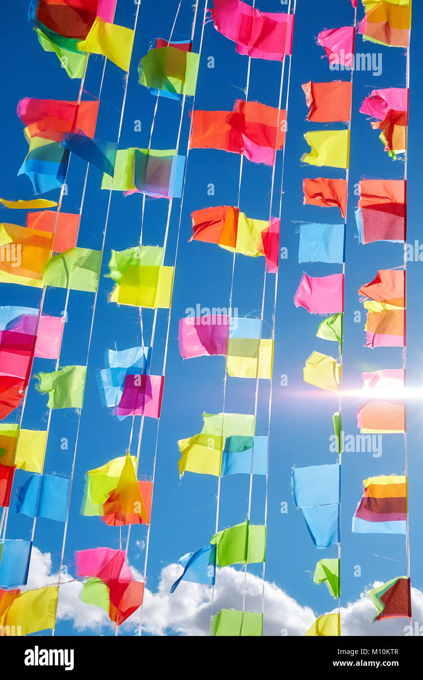 Colorful prayer flags against the sun and blue sky. Stock Photo