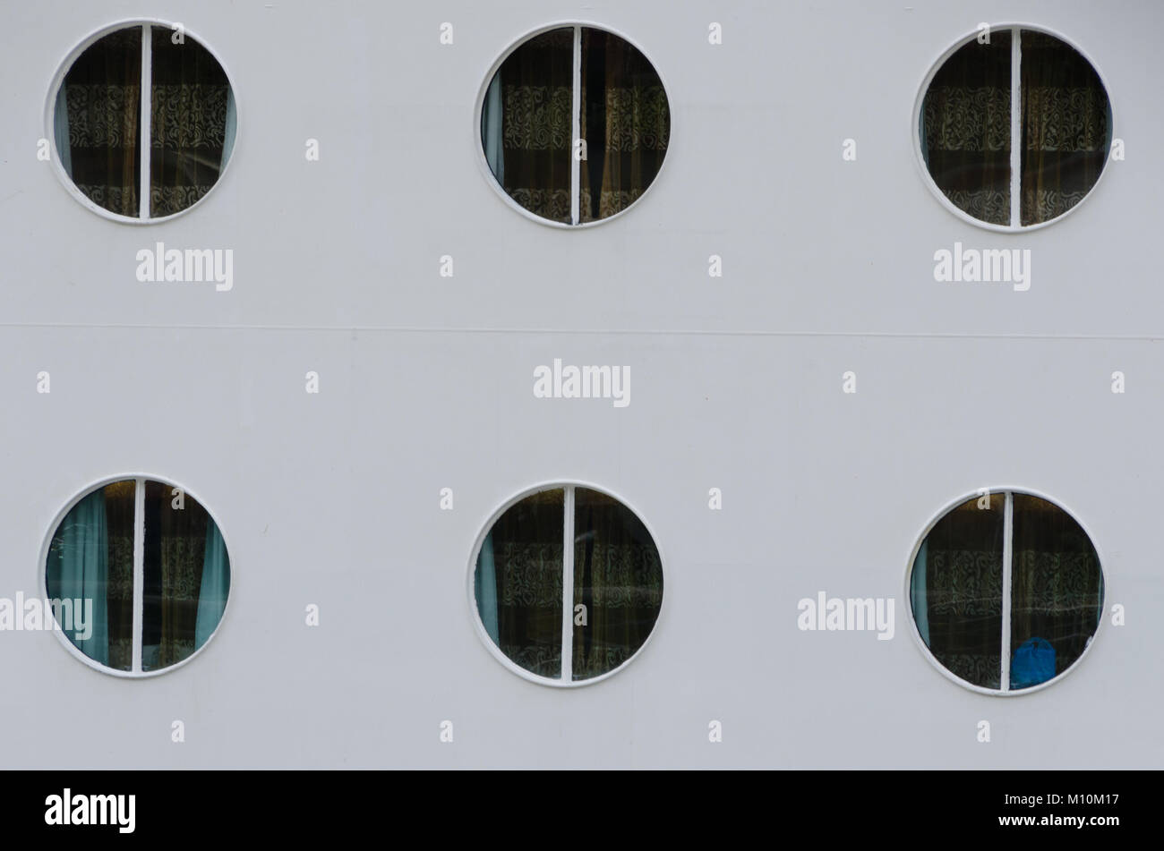 Close up of six port holes on cruise ship. Abstract minimalist background concept sea travel. Stock Photo