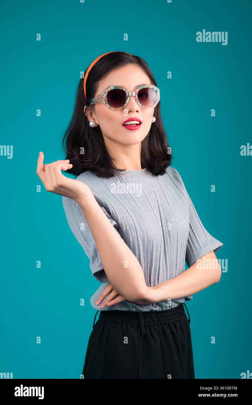 Smiling asian woman dressed in pinup style dress wearing eyeglasses