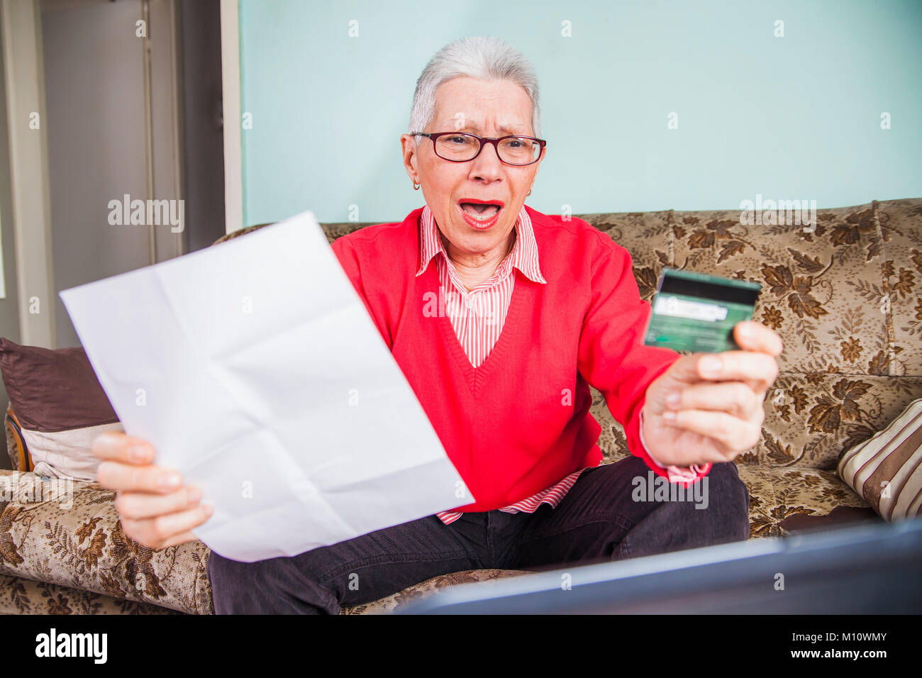 Senior old woman shocked by her credit card bill Stock Photo