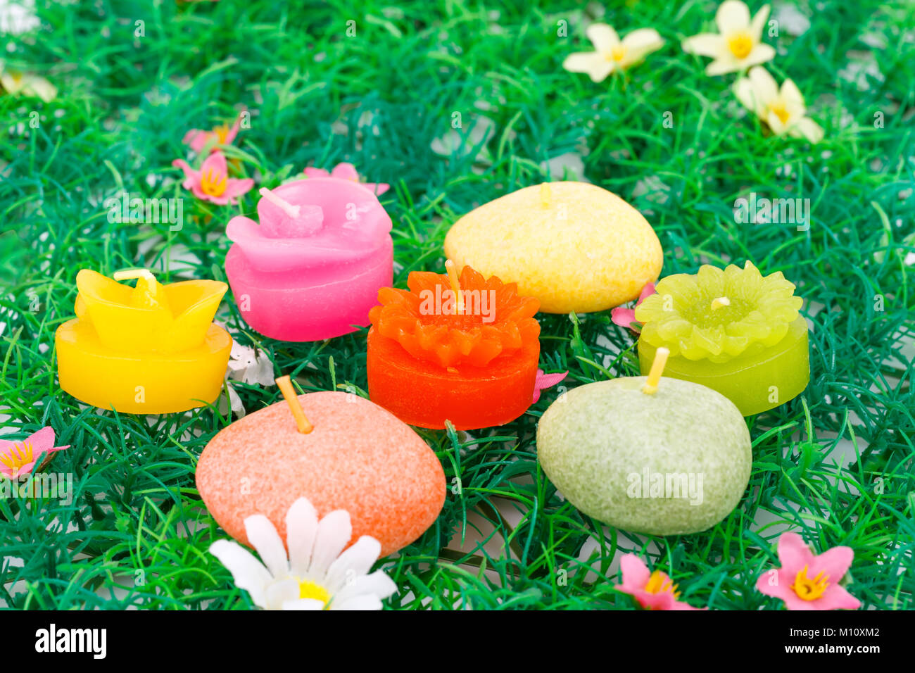 Colorful candles on artificial grass background. Stock Photo