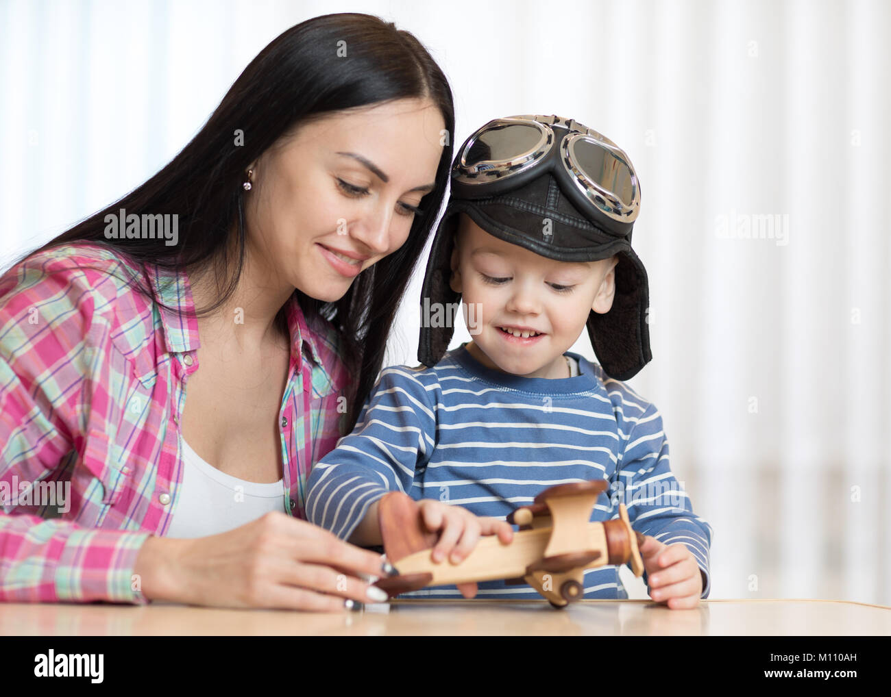 Mother and son are playing with wooden planes. Stock Photo