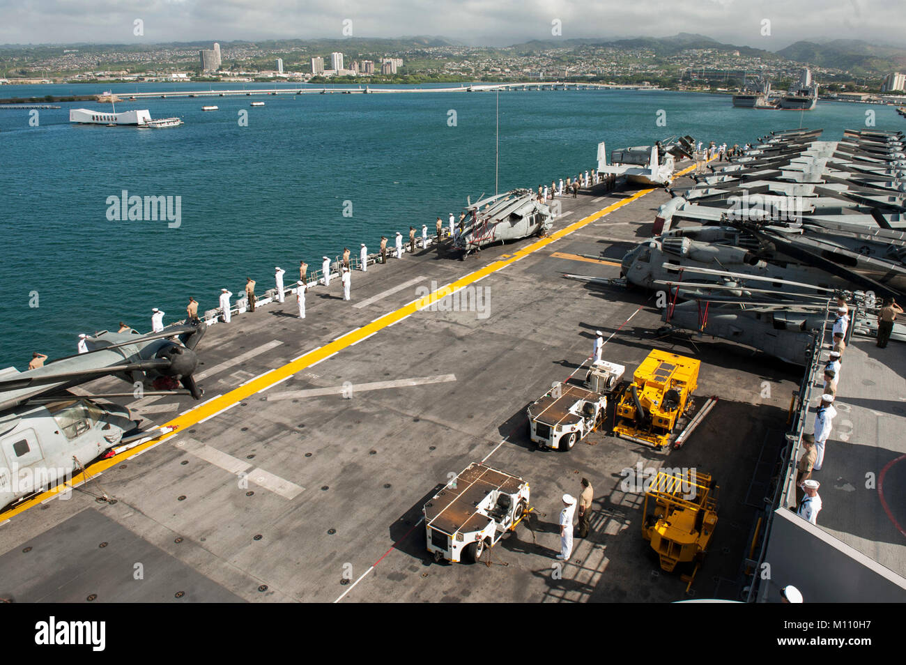 180123-N-ZS023-029  PEARL HARBOR (Jan. 23, 2018) Sailors and Marines aboard the amphibious assault ship USS America (LHA 6) render honors to the USS Arizona memorial as the ship arrives in Pearl Harbor, Hawaii, for a scheduled port visit. America, part of the America Amphibious Ready Group, with the embarked 15th Marine Expeditionary Unit (15th MEU), is returning from a 7-month deployment to the U.S. 3rd, 5th and 7th fleet areas of operations. (U.S. Navy photo by Mass Communication Specialist 3rd Class Vance Hand/Released) Stock Photo