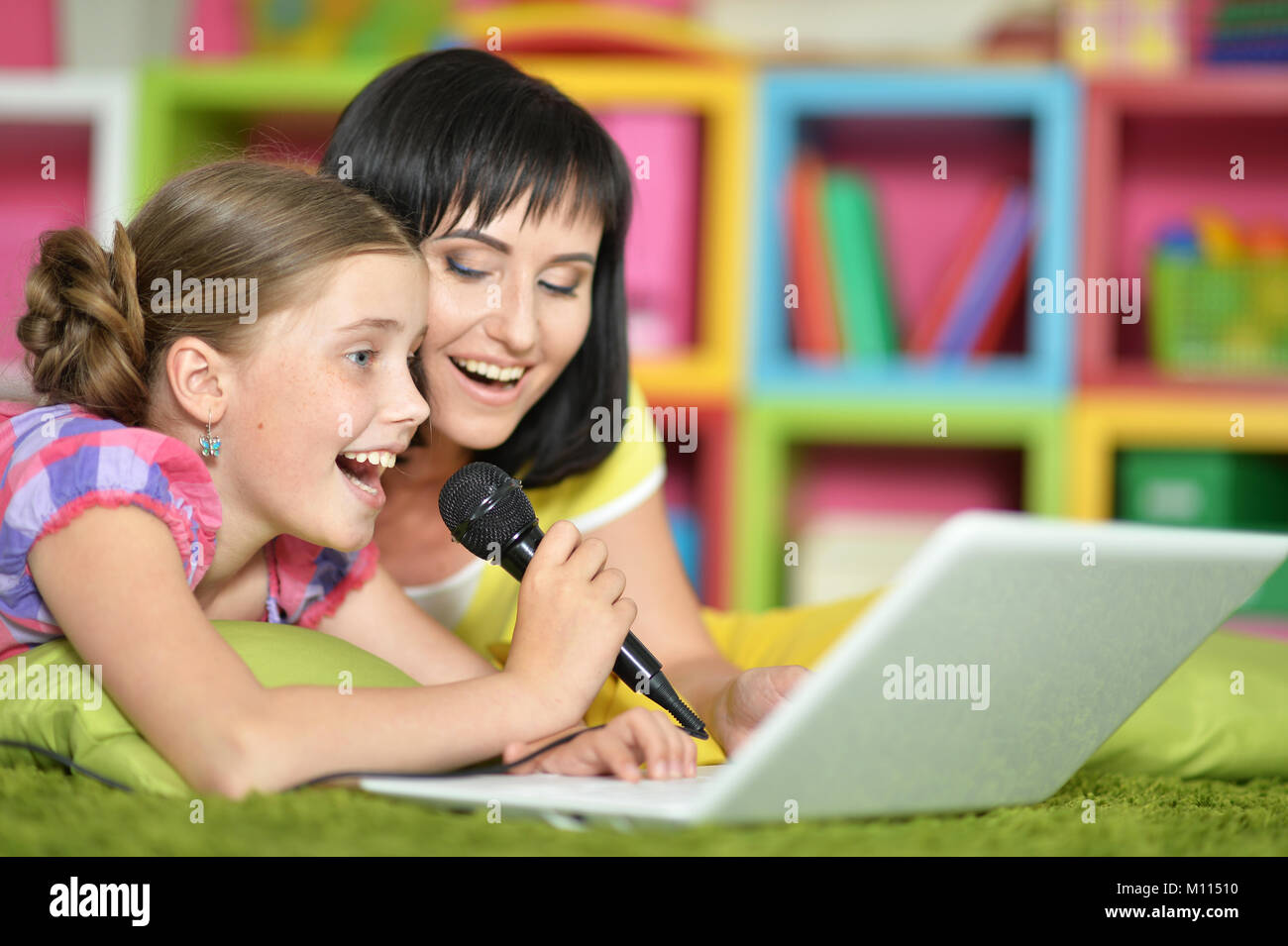 mother and daughter singing karaoke Stock Photo Alamy