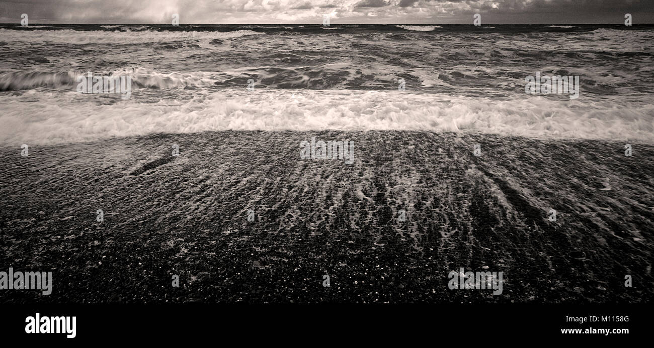 Waves breaking on a pebble beach in rough weather Stock Photo
