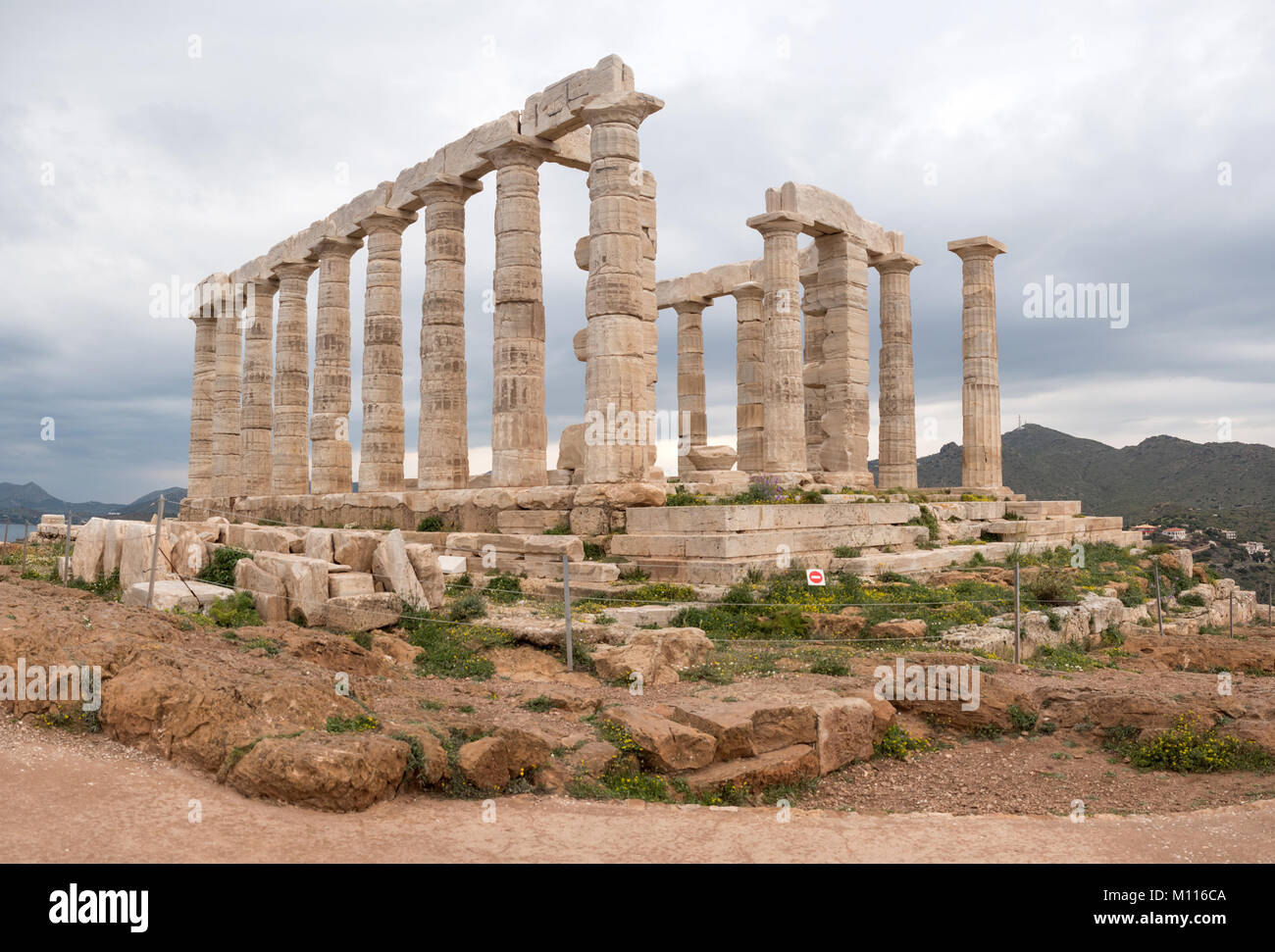 Ruins of an ancient Greek temple of Poseidon under dramatic cloudy sky, Cape Sounion, Greece Stock Photo