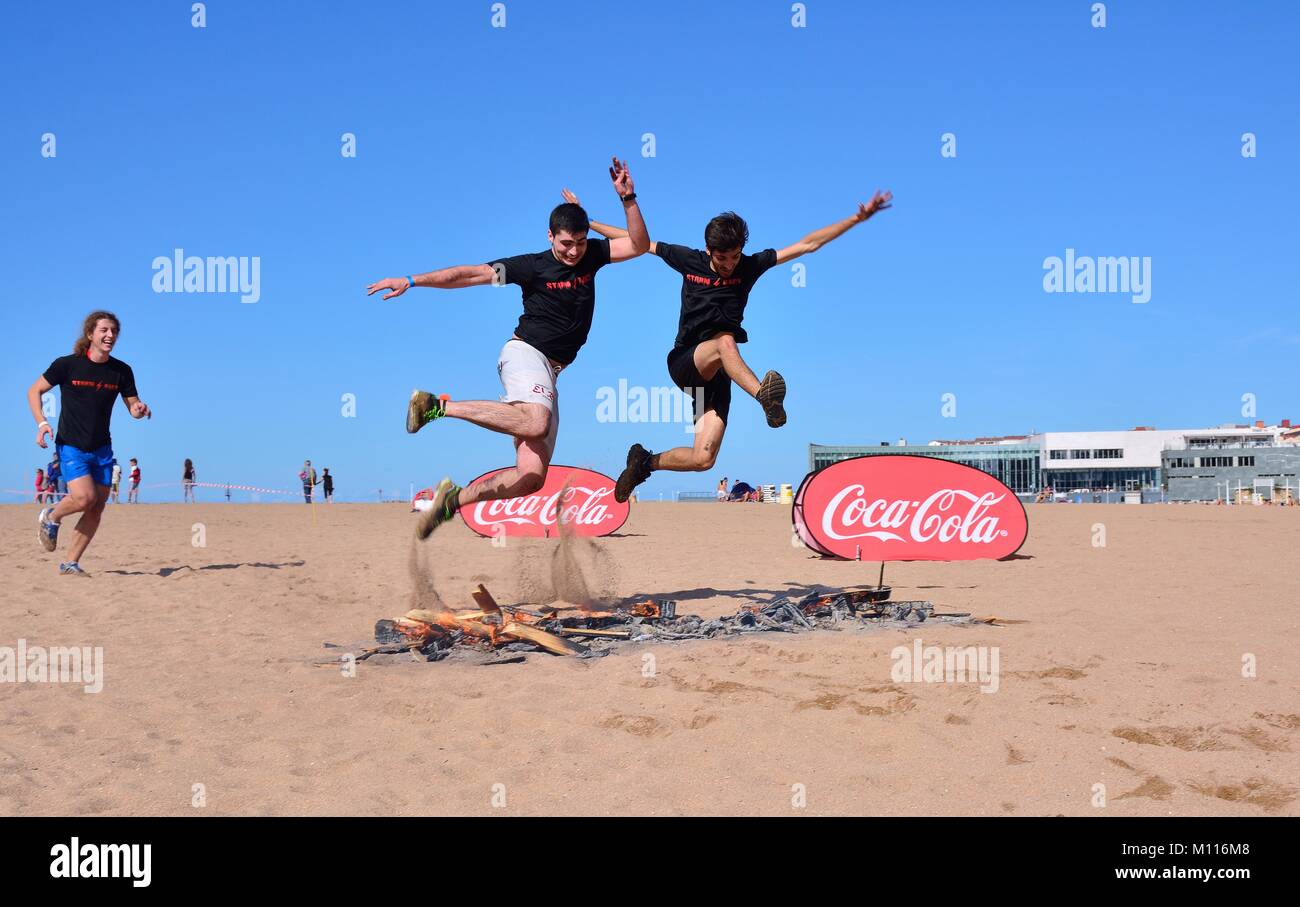 GIJON, SPAIN - SEPTEMBER 19: Storm Race, an extreme obstacle course in September 19, 2015 in Gijon, Spain. Runners jumping a barrier of fire. Stock Photo