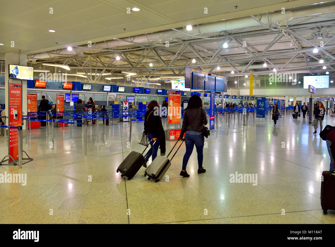 Check-in counters in departure hall at Athens international airport, people with baggage Stock Photo