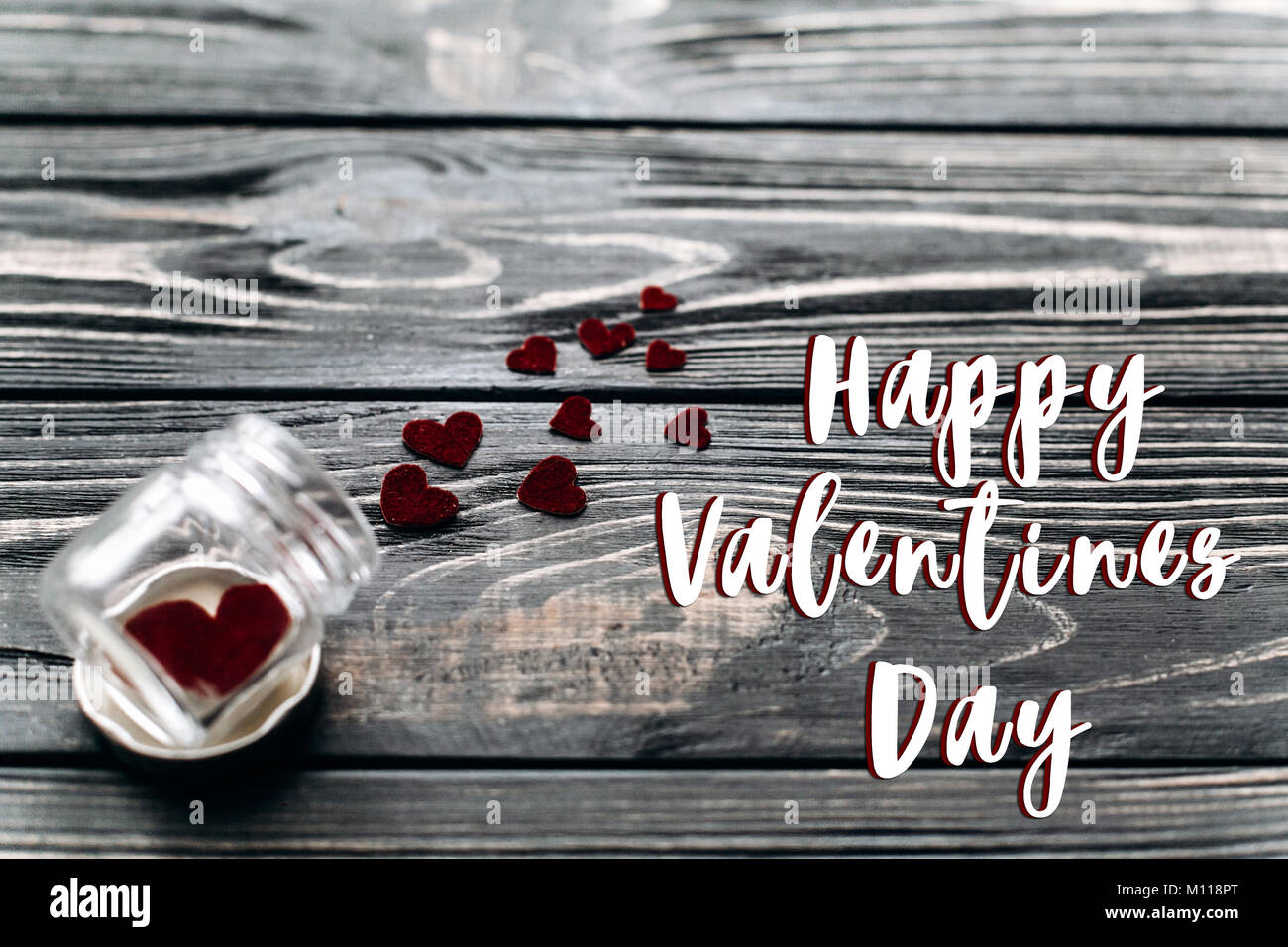 happy valentines day text sign concept. stylish velvet hearts in glass jar  on black rustic wooden background. happy valentines day. unusual greeting c  Stock Photo - Alamy