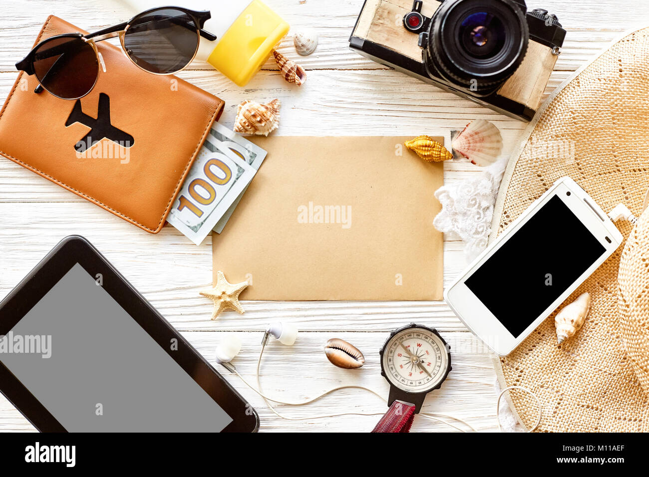 summer travel wanderlust concept, space for text, flat lay. empty tablet card, camera  sunglasses compass passport money phone hat shells on white woo Stock Photo