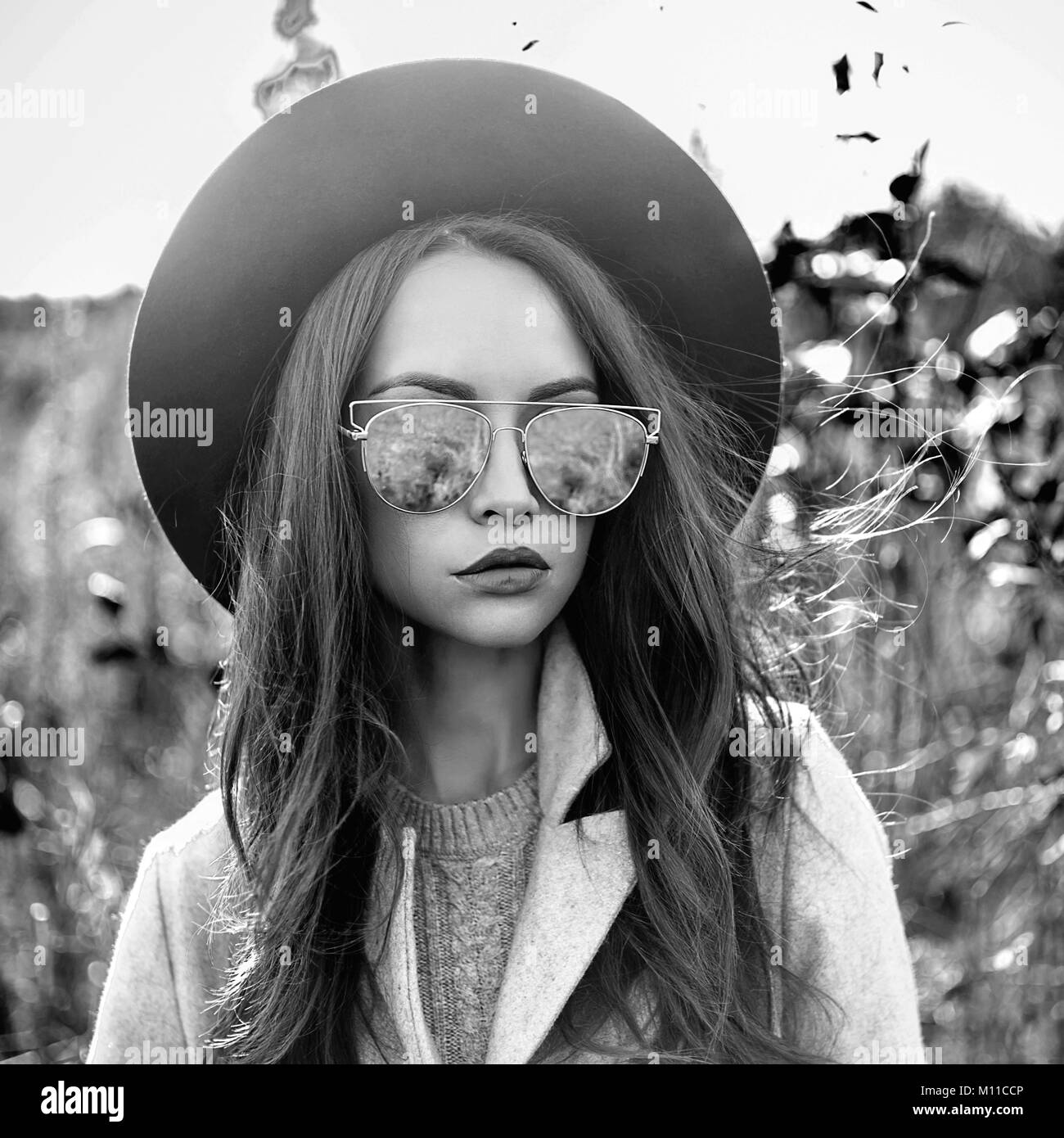 Black and white outdoor fashion photo of young beautiful lady in autumn ...
