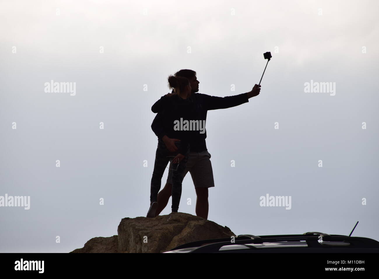 Silhouette of young couple taking selfie on Highway 1, Big Sur, California Stock Photo