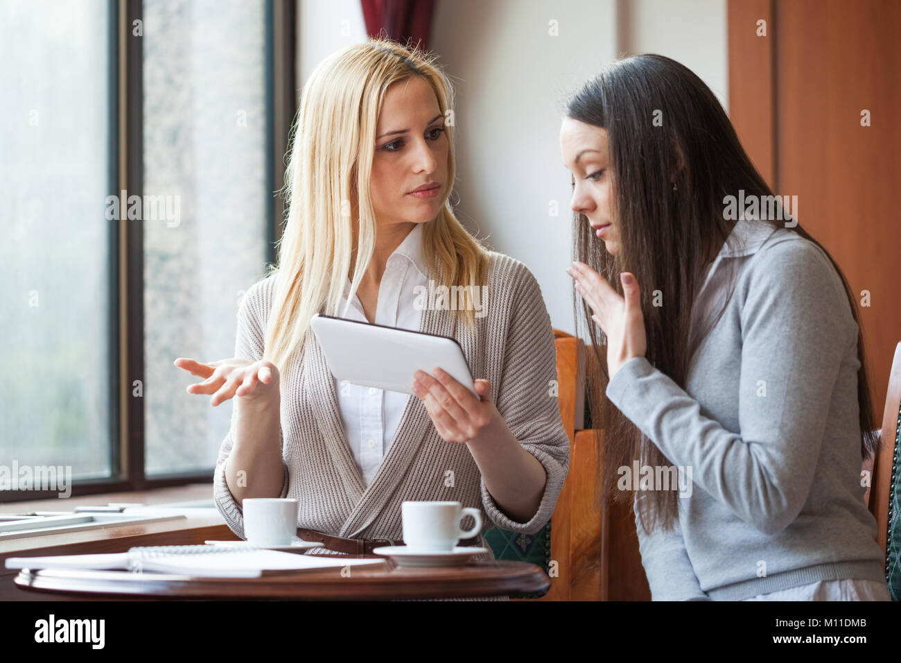 Two young women in cafe Stock Photo - Alamy