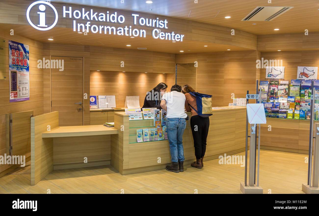 Hokkaido, Japan - 27 December 2017 - Couple of tourists ask for travel information from travel advisor at the Hokkaido Tourist Information Center insi Stock Photo
