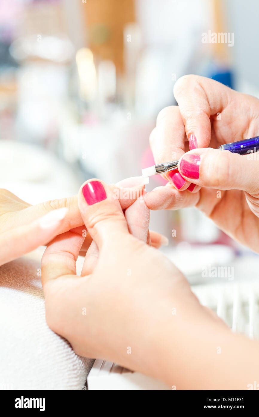 Process of nail treatment, applying white paint on fingernail Stock