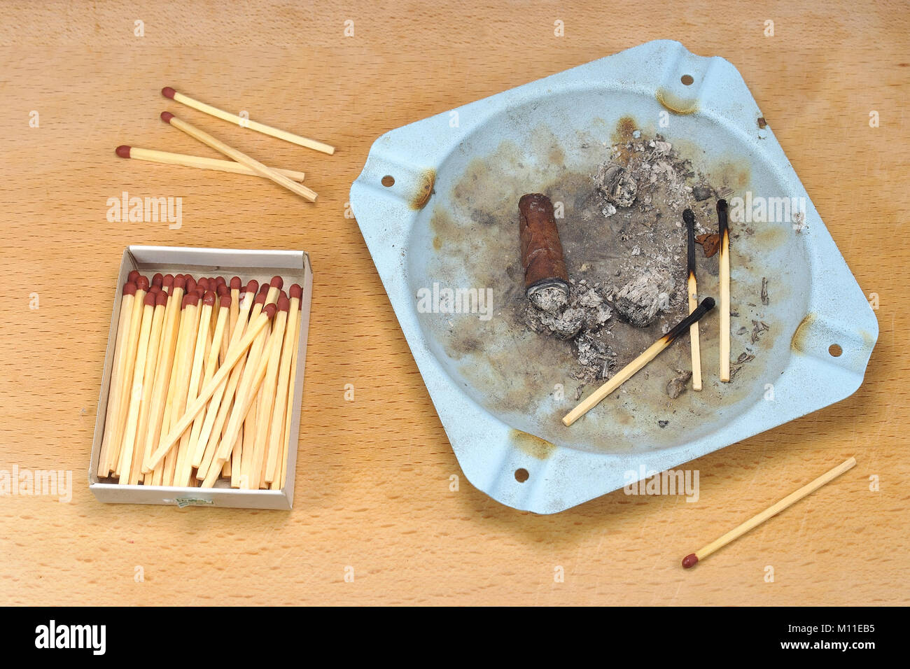 Smoked cigar, in an ashtray, and matches. Stock Photo