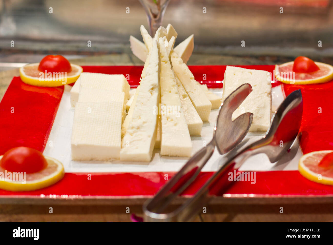 Sliced white cheese on a red dish with silver spoon Stock Photo Alamy