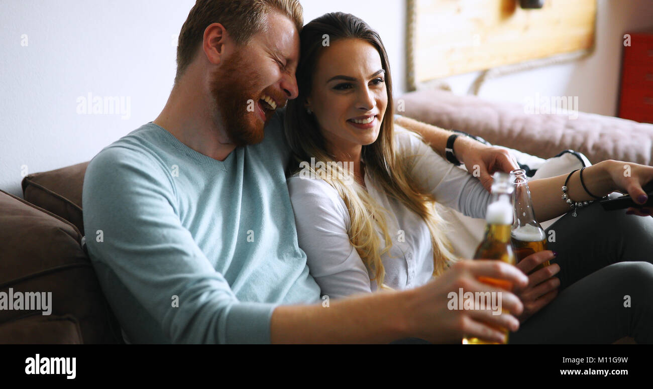 Happy couple drinking beer and toasting at home Stock Photo