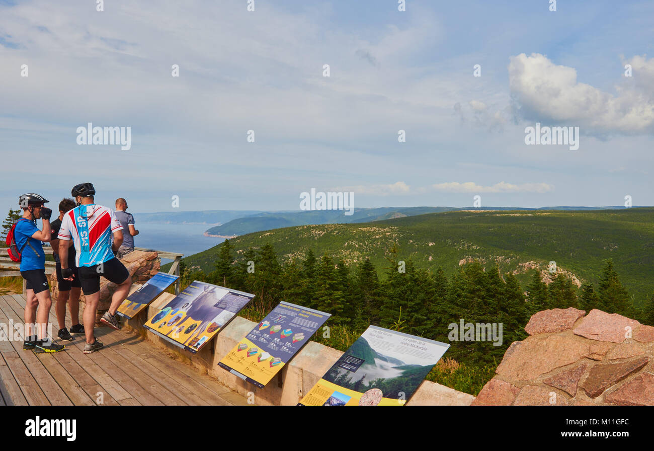 Cyclists on viewing platform with information boards in the Cape Breton Highlands National Park, Cape Breton Island, Nova Scotia, Canada Stock Photo