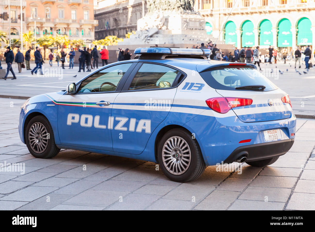 Milano, Italy - January 19, 2018: Blue and white Alfa Romeo Giulietta, Italian police car patrols Piazza del Duomo, central city square of Milano, rea Stock Photo