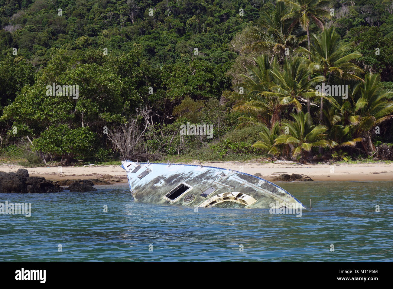Shipwrecked yacht on rocks near entrance to Mourilyan harbour, far north Queensland, Australia. No PR Stock Photo