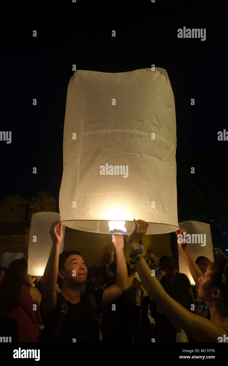Couple releasing lantern amongst crowd during festival, Chiang Mai, Thailand. No MR Stock Photo