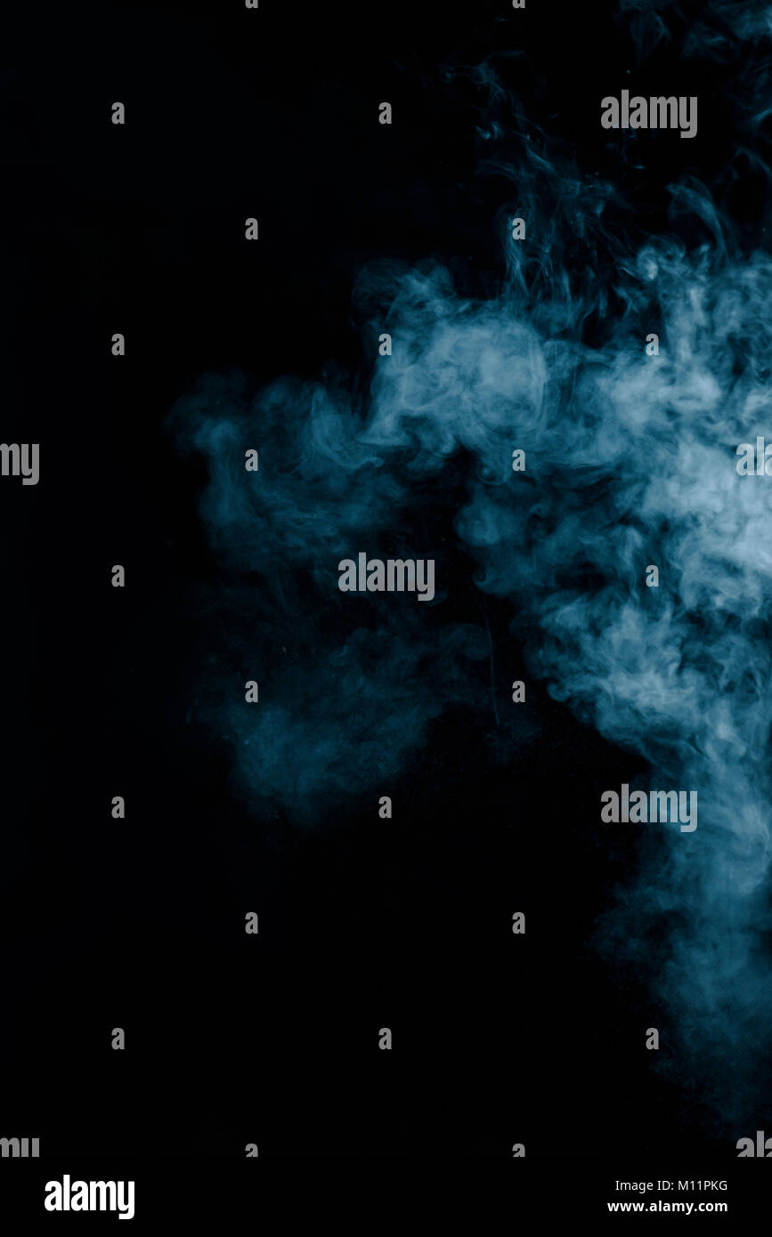 Steam texture from a hot drink on a black background. Blue smoke with copy space. Stock Photo
