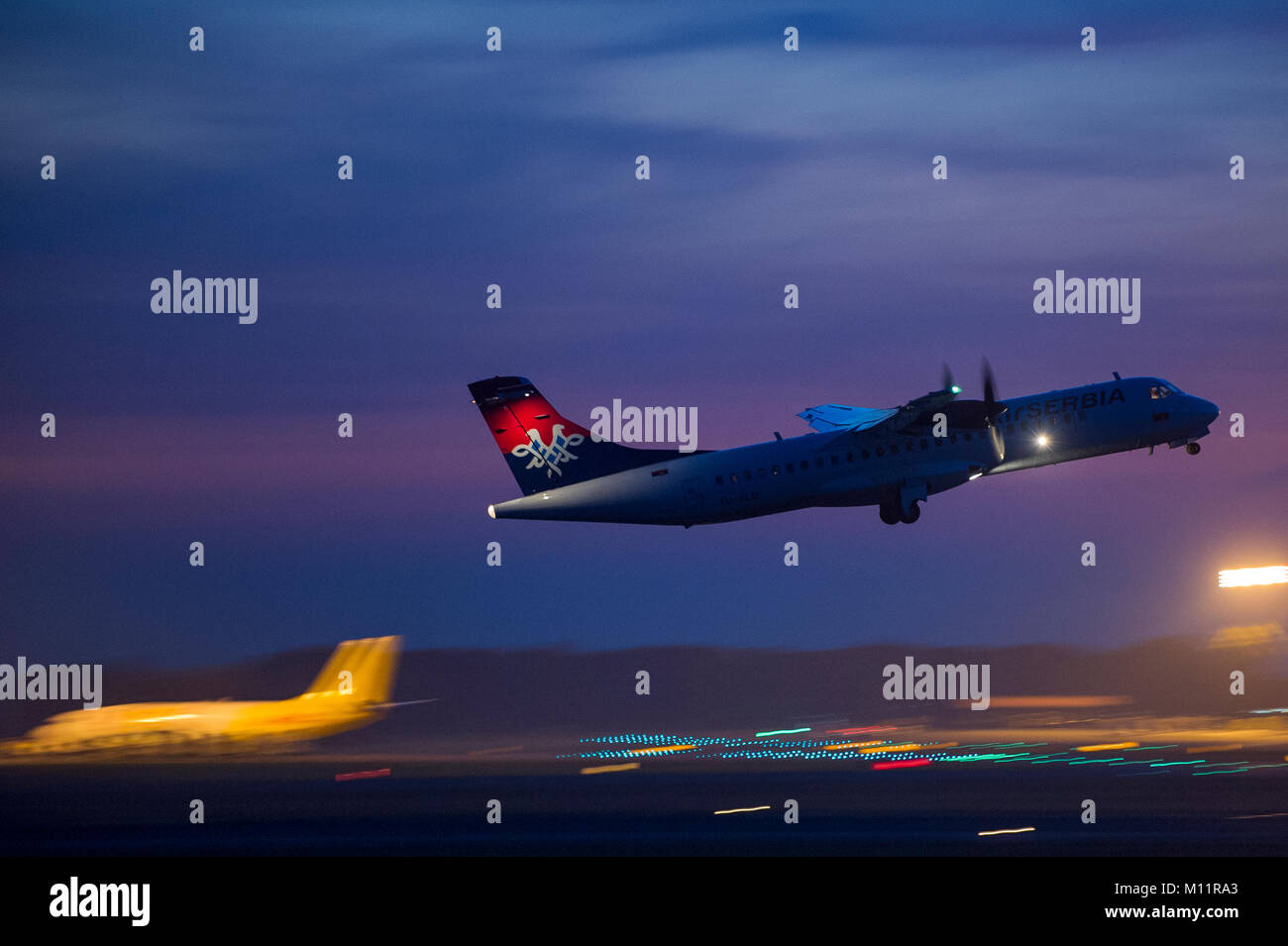 Air Serbia ATR-72 turboprop regional commuter aircraft taking off in dusk Stock Photo