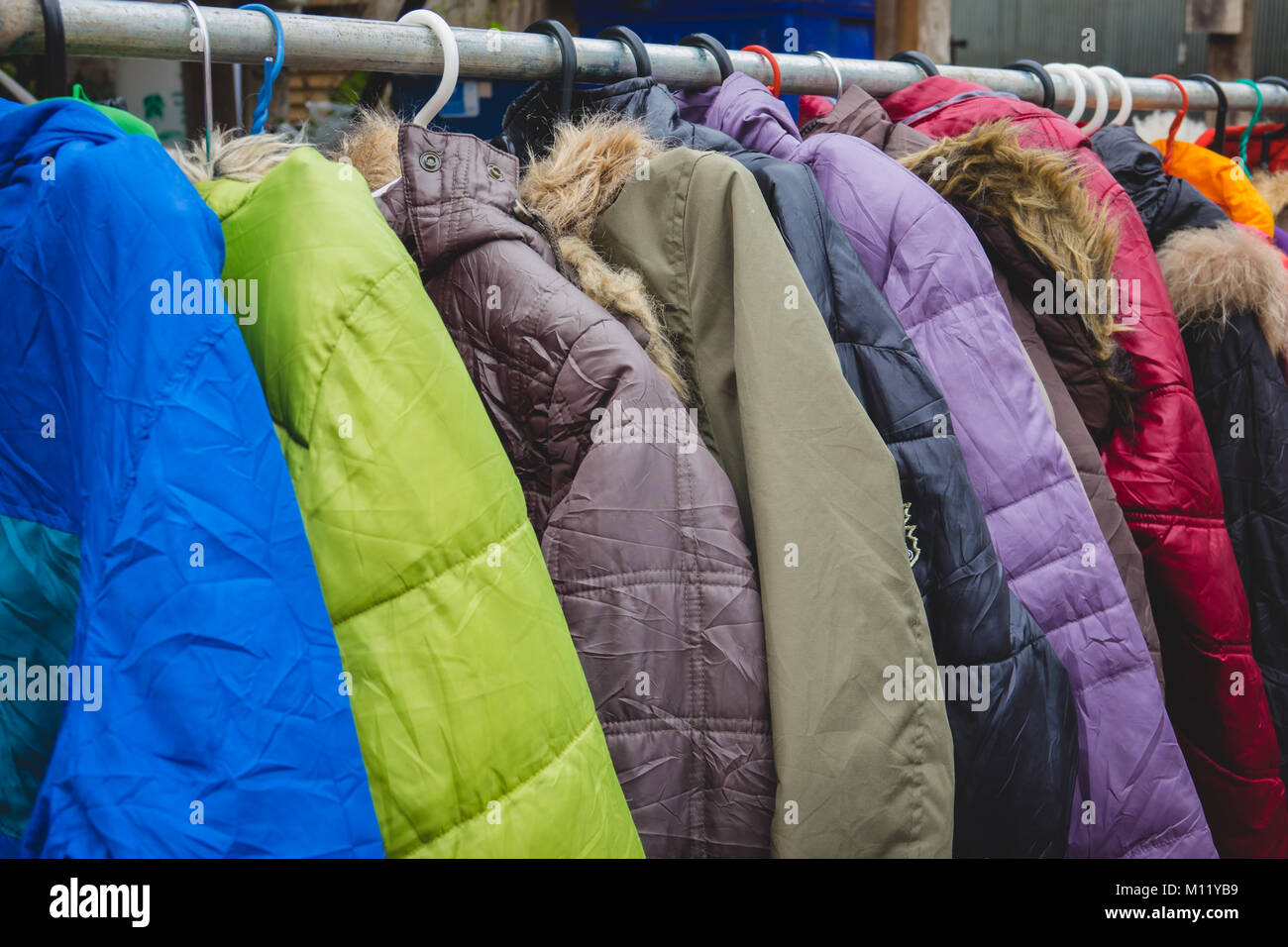 Fashion winter coats hanged on a clothes rack Stock Photo - Alamy